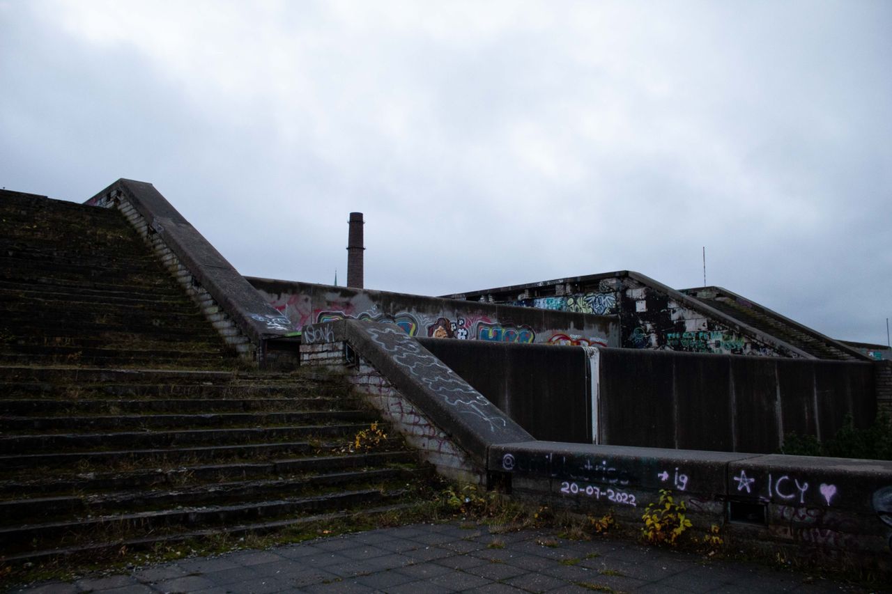 Concrete stairs adorned with colorful graffiti under a cloudy sky.